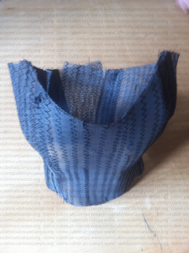 Bustier con las varillas cortadas a medida y los pasaballenas cerrados, manteniéndose en pie sobre la mesa de trabajo.